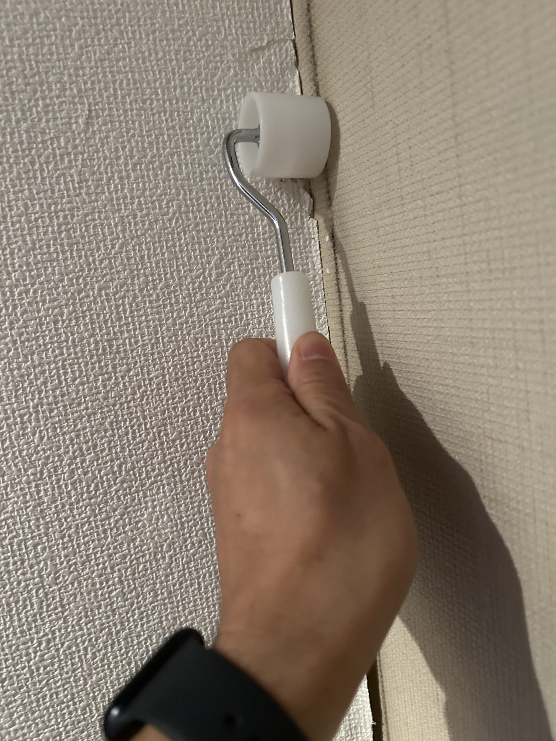 ローラーで壁紙を密着させる