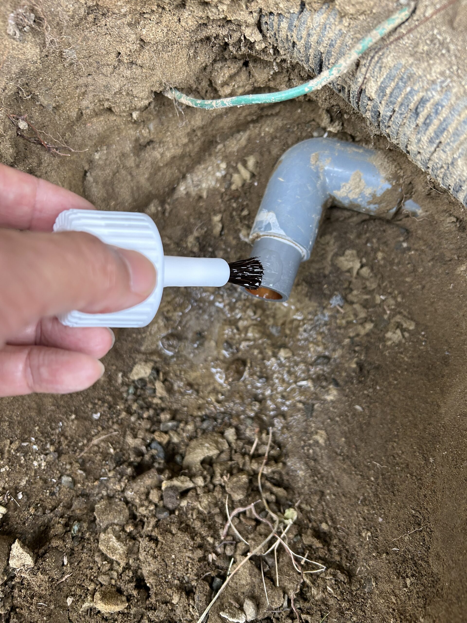 給水管に接着剤を塗っているところ
