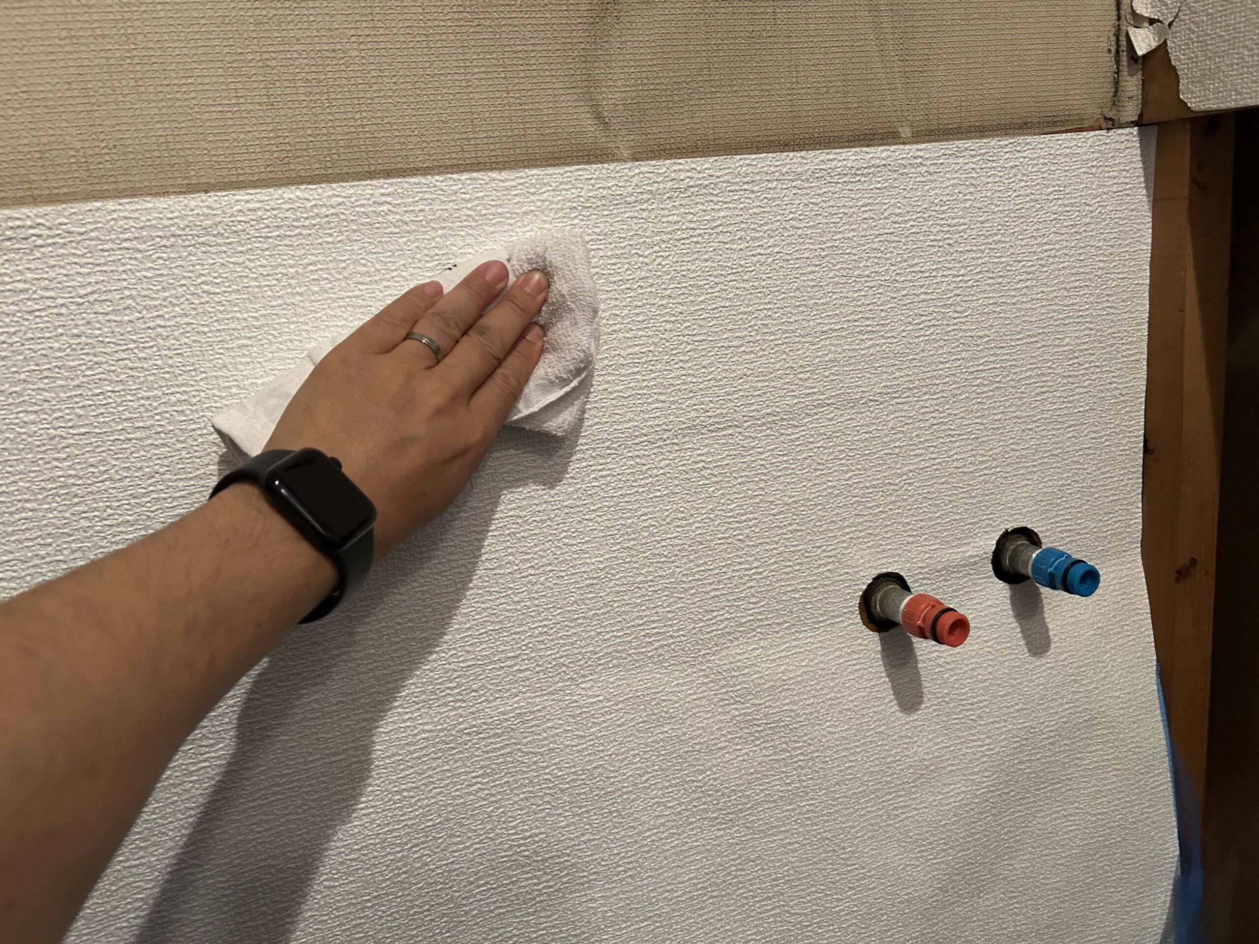 ハケの代わりにタオルで壁紙を押さえる